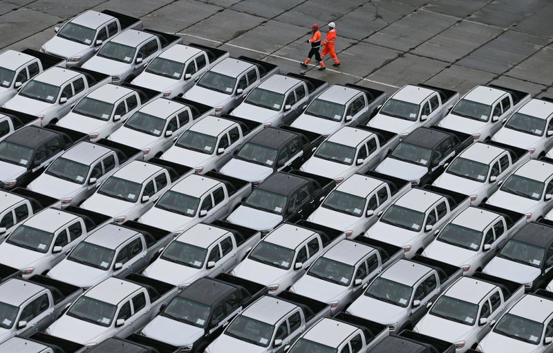 &copy; Reuters. FILE PHOTO: Workers walk past new Chinese cars unloaded from a ship at a commercial port in Vladivostok, Russia August 25, 2023. REUTERS/Tatiana Meel/File Photo