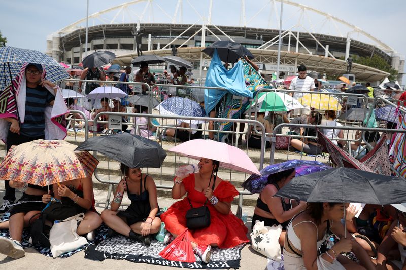 &copy; Reuters. Pessoas tentam se proteger do calor do lado de fora de estádio antes de show de Taylor Swift no Rio de Janeiro
18/11/2023
REUTERS/Pilar Olivares