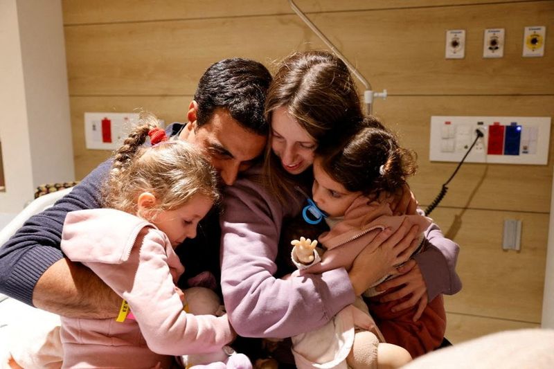 &copy; Reuters. Aviv Asher, 2,5-year-old, her sister Raz Asher, 4,5-year-old, and mother Doron, react as they meet with Yoni, Raz and Aviv's father and Doron's husband, after they returned to Israel to the designated complex at the Schneider Children's Medical Center, du