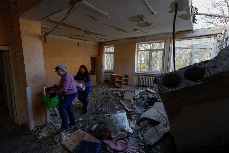 © Reuters. Employees carry items inside a building of a kindergarten damaged during Russian drone strikes, amid Russia's attack on Ukraine, in Kyiv, Ukraine November 25, 2023. REUTERS/Valentyn Ogirenko