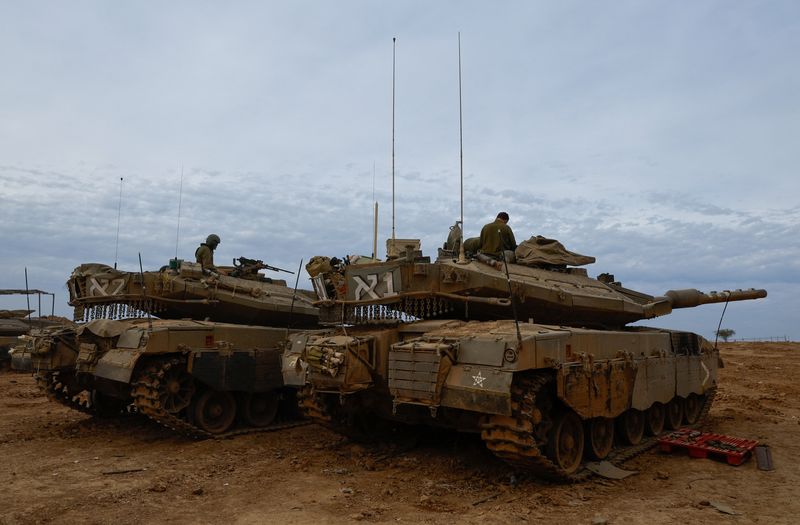 &copy; Reuters. Des soldats israéliens sont assis dans des chars Merkava près de la frontière entre Israël et Gaza, lors d'une trêve temporaire entre le Hamas et Israël. /Photo prise le 25 novembre 2023 au sud d'Israël/REUTERS/Alexander Ermochenko