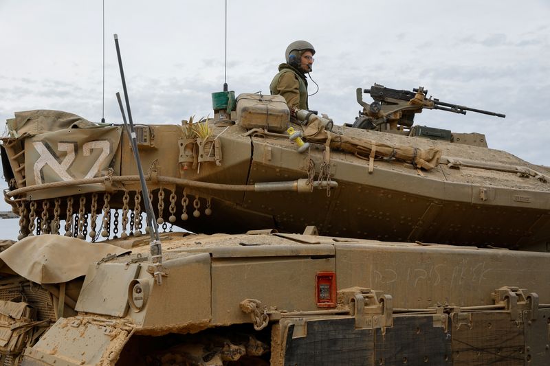 © Reuters. An Israeli soldier sits atop a Merkava tank near the Israel-Gaza border, during a temporary truce between Hamas and Israel, in southern Israel, November 25, 2023. REUTERS/Alexander Ermochenko