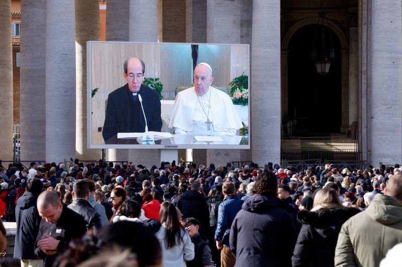 © Reuters. باولو برايدا مساعد البابا فرنسيس يقرأ عظة البابا لدى ظهورهما على شاشة في ساحة القديس بطرس يوم الأحد. تصوير: ريمو كاسيلي - رويترز