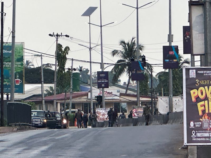 © Reuters. مسلحون ملثمون يرتدون زي جيش في شارع بعد أن هاجم مسلحون مجهولون ثكنات عسكرية وحاولوا اقتحام مستودع أسلحة في فريتاون في سيراليون يوم الأحد. تصوير: أومارو فوفانا  -رويترز.