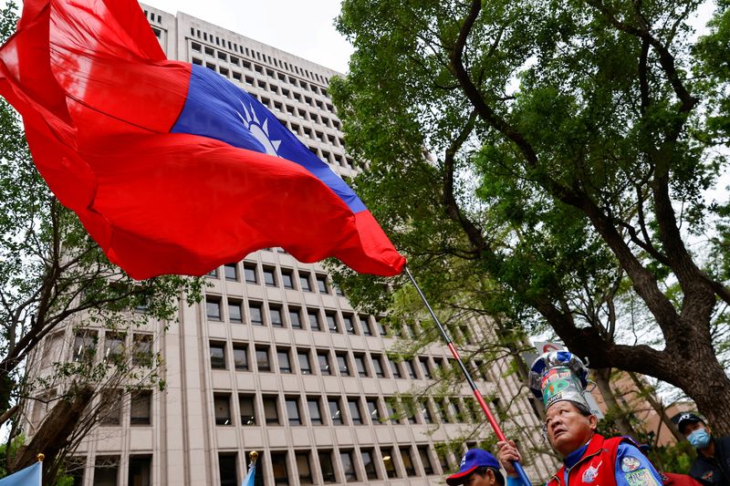 &copy; Reuters. FILE PHOTO: A supporter of the main opposition party Kuomintang (KMT) waves a Taiwanese flag outside of the Central Election Commission in Taipei, Taiwan November 24, 2023. REUTERS/Ann Wang/File Photo