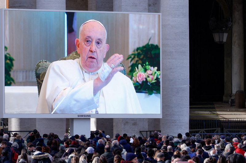 &copy; Reuters. البابا فرنسيس يظهر علي شاشة في ساحة القديس بطرس يوم الأحد. تصوير : ريمو كاسيلي - رويترز.