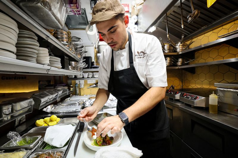 &copy; Reuters. Lo chef Davide Sanna lavora nella cucina di Piccola Cucina nel quartiere SoHo di New York, Stati Uniti, 22 novembre 2023.  REUTERS/Brendan McDermid