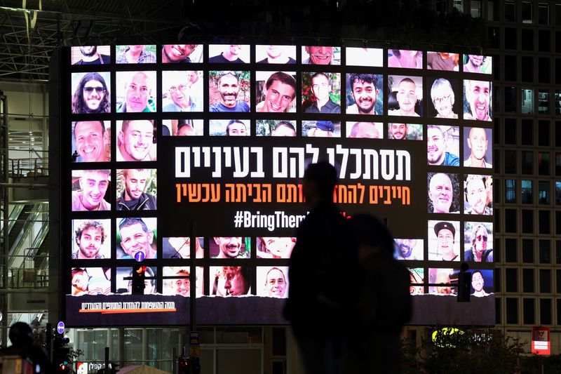 © Reuters. FILE PHOTO: A screen displays photos of people who were abducted by Hamas gunmen during the October 7 attack on Israel, in Tel Aviv, Israel, November 27, 2023. REUTERS/Athit Perawongmetha/File Photo