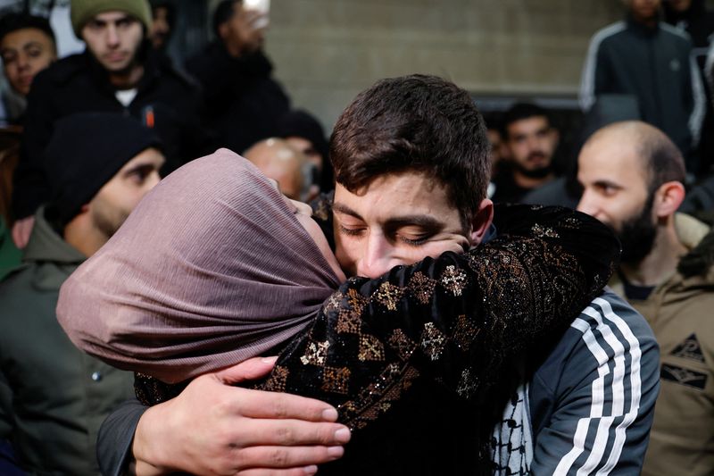 &copy; Reuters. أحد الأسرى الفلسطينيين يعانق والدته في أثناء استقبال أسرته له لدى عودته إلى منزله في الضفة الغربية في الساعات الأولى من صباح يوم الاثنين ضم