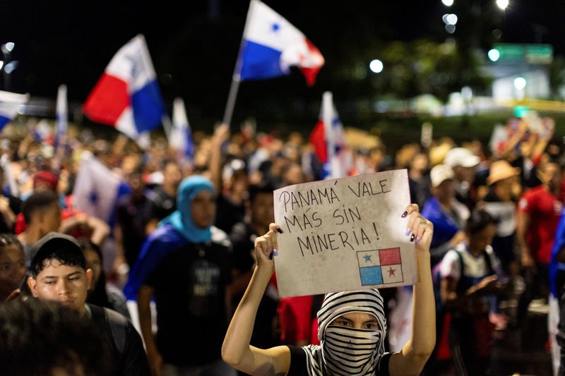 &copy; Reuters. A demonstrator holds a sign during a protest against a new mining contract signed into law by Panama's government, providing Canadian mining firm First Quantum a 20-year mining right, with an option to extend for another 20 years, in Panama City October 2