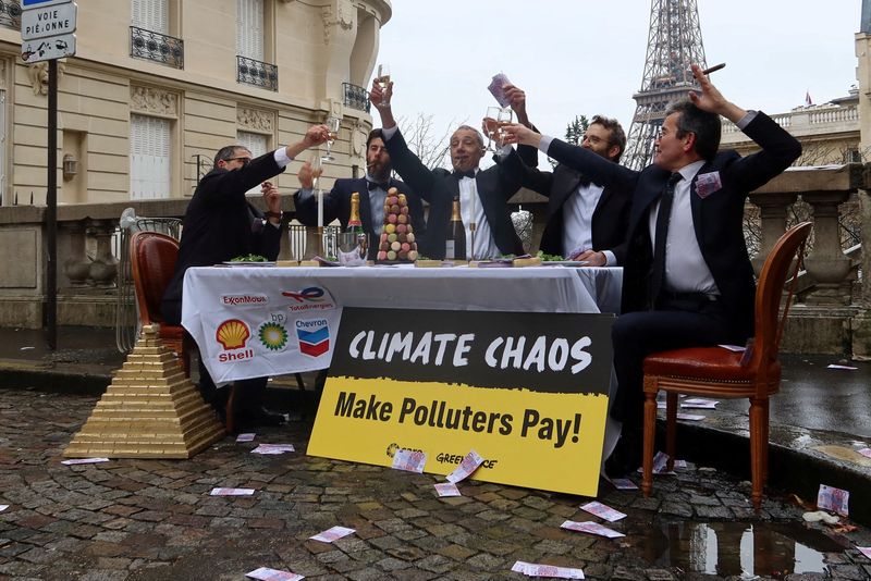 &copy; Reuters. FILE PHOTO: Climate activists disguised as CEOs of major oil companies take part in a fake banquet celebrating profits, in call on states taking part in COP28 climate conference to finance loss and damage fund by taxing fossil fuel profits, near the Eiffe