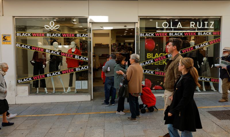 &copy; Reuters. FILE PHOTO: People walk past a shop displaying Black Friday sales signs, during Black Friday in Ronda, Spain November 24, 2023. REUTERS/Jon Nazca/File Photo