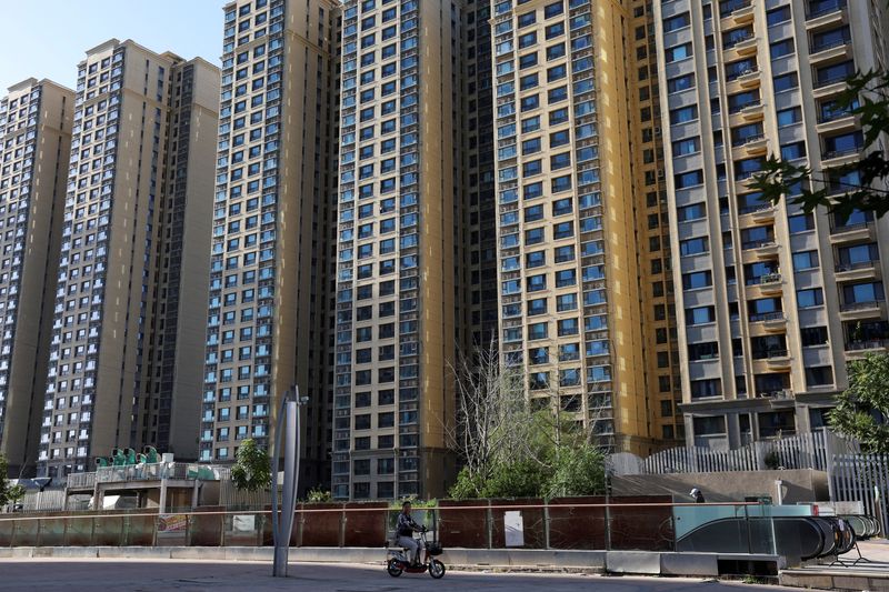 &copy; Reuters. FILE PHOTO: A woman rides a scooter past residential buildings at an Evergrande residential complex in Beijing, China September 27, 2023. REUTERS/Florence Lo/File Photo