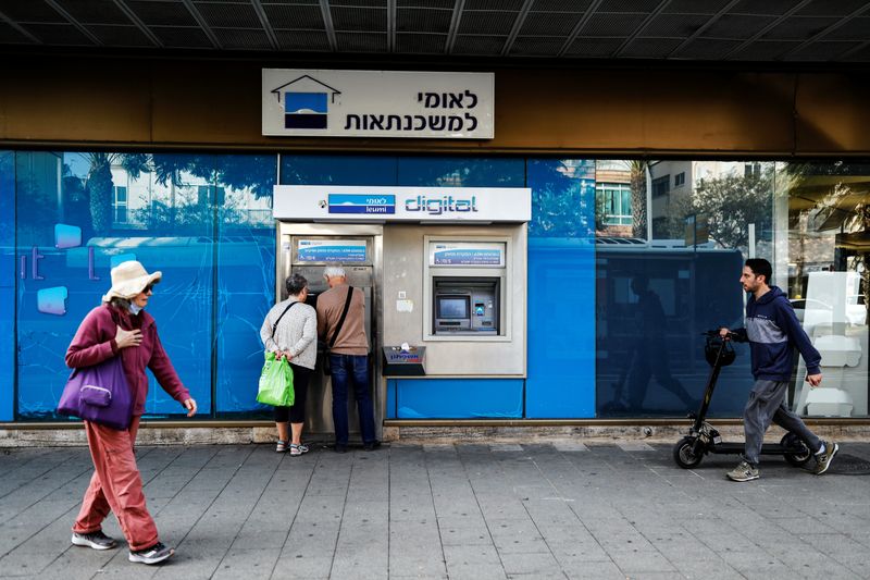 &copy; Reuters. People use an ATM at a branch of Bank Leumi in Tel Aviv, Israel November 22, 2021. Picture taken November 22, 2021. REUTERS/Corinna Kern