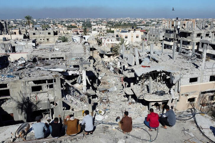 &copy; Reuters. Persone palestinesi guardano le case distrutte dai colpi israeliani durante il conflitto, nel corso della tregua temporanea tra Israele e il gruppo islamista palestinese Hamas, nel campo profughi di Khan Younis, nel sud della Striscia di Gaza, 29 novembre