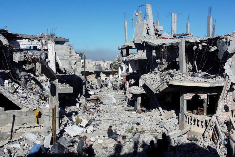 &copy; Reuters. فلسطينيون يطهون الطعام وسط منازل مدمرة جراء القصف الإسرائيلي خلال هدنة مؤقتة بين إسرائيل وحركة حماس في مخيم للاجئين بخان يونس جنوب قطاع غزة