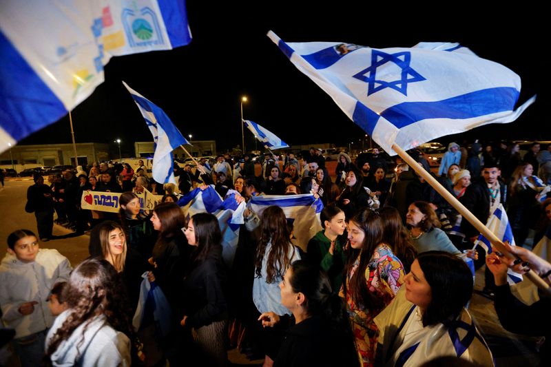 &copy; Reuters. Des personnes brandissent des drapeaux israéliens à Ofakim, en Israël, après la libération des otages capturés lors de l'attaque du 7 octobre par le Hamas. /Photo prise le 30 novembre 2023/REUTERS/Alexander Ermochenko 