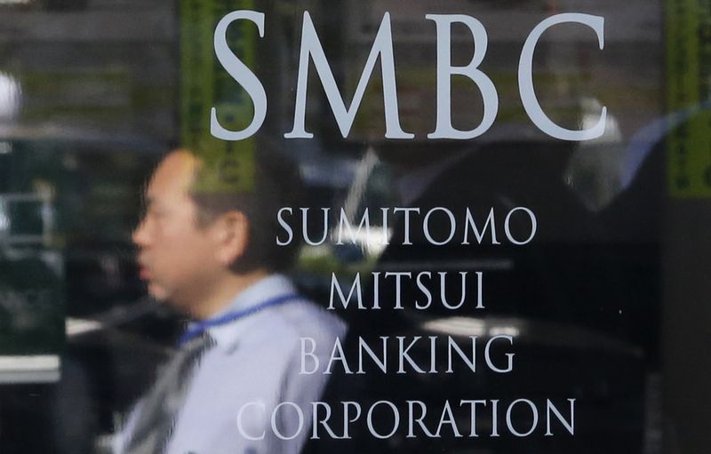&copy; Reuters. A man is reflected on a sign outside a branch of Sumitomo Mitsui Banking Corporation in Tokyo November 13, 2014. REUTERS/Toru Hanai/File Photo