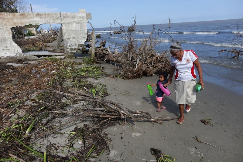 &copy; Reuters. Imagen de archivo de dos personas caminando junto a los restos de una casa destruida por el aumento del nivel del mar en El Bosque, México. 7 noviembre 2022. REUTERS/Gustavo Graf