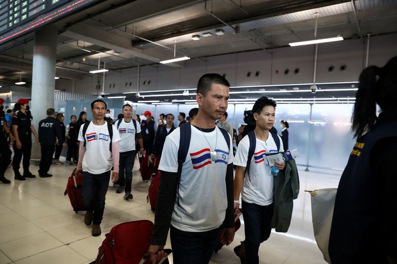 © Reuters. المجموعة الأولى من المواطنين التايلانديين الذين أفرجت عنهم حركة حماس يصلون إلى وطنهم بعد احتجازهم لقرابة أسبوعين في غزة يسيرون في مطار ببانكوك يوم الخميس في صورة لرويترز.
