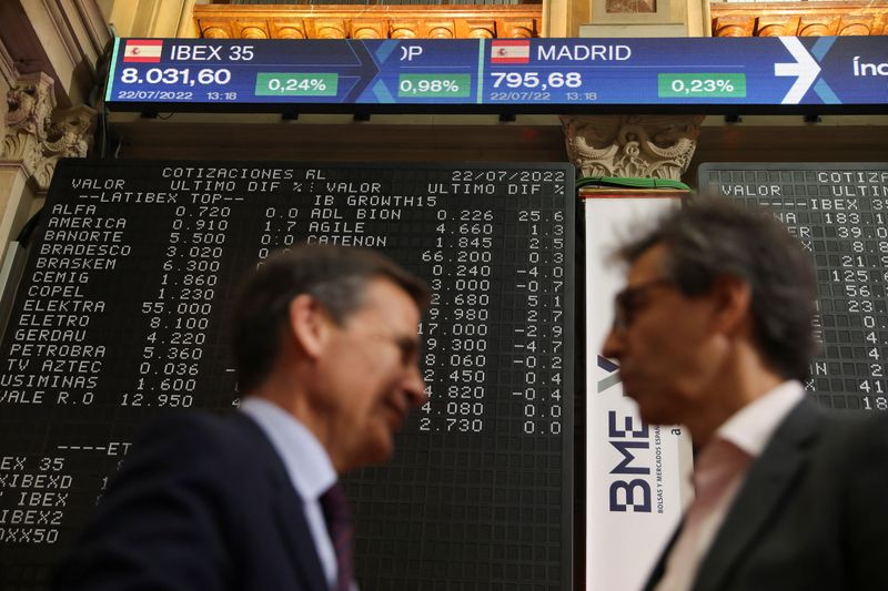 &copy; Reuters. Dos hombres hablando frente a los paneles electrónicos que muestran el valor del Ibex-35 en la bolsa de Madrid, España. 22 de julio de 2022. REUTERS/Isabel Infantes