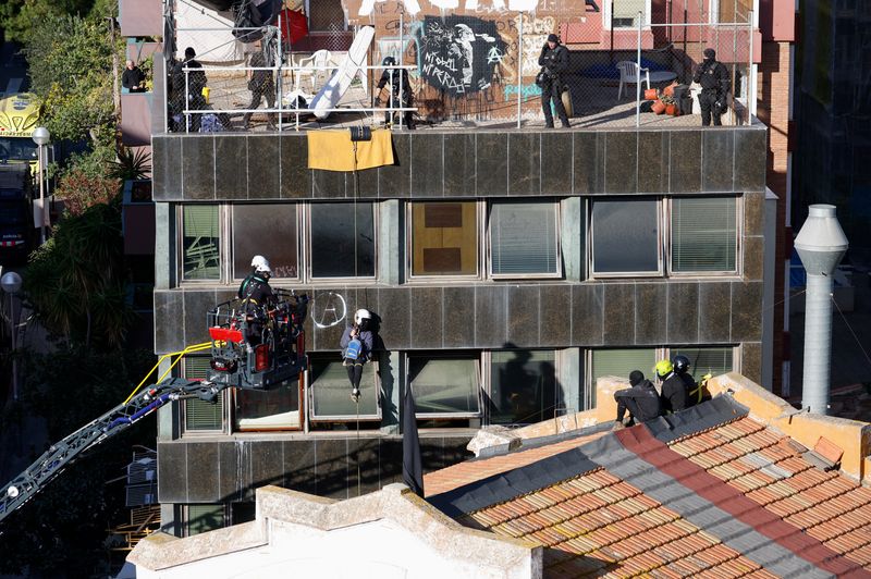&copy; Reuters. Un okupa cuelga de una cuerda de escalada mientras agentes de policía intentan desalojar los edificios okupados de Kubo y La Ruina en Barcelona, España, 30 de noviembre de 2023. REUTERS/Albert Gea