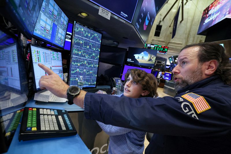 © Reuters. FILE PHOTO: A specialist trader works with his son during a traditional bring-your-kids-to-work day on the floor at the New York Stock Exchange (NYSE) in New York City, U.S., November 24, 2023.  REUTERS/Brendan McDermid/File Photo