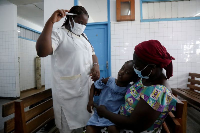 &copy; Reuters. FOTO DE ARCHIVO: Una enfermera se prepara para tomar la temperatura a un niño con malaria en el Hospital General Marcory de Abiyán, Costa de Marfil. 7 de octubre, 2021. REUTERS/Luc Gnago/Archivo