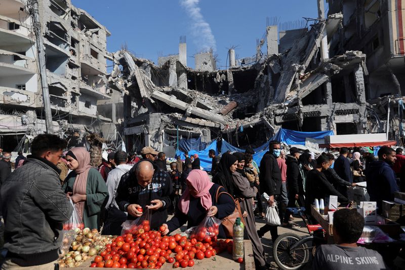 &copy; Reuters. Tiendas palestinas en un mercado al aire libre cerca de las ruinas de casas y edificios destruidos por los ataques israelíes durante el conflicto, en medio de una tregua temporal entre Hamás e Israel, en el campo de refugiados de Nuseirat, en el centro 
