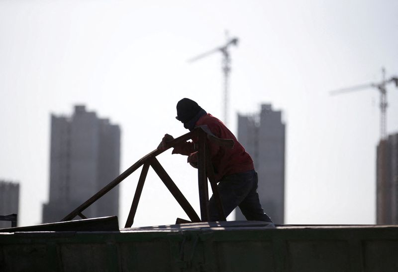 &copy; Reuters. FILE PHOTO: A man works near apartment blocks under construction on the outskirts of Beijing, China December 16, 2017. REUTERS/Jason Lee/File Photo
