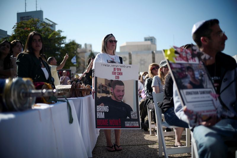 &copy; Reuters. Una mujer sostiene un cartel durante una ceremonia religiosa para rezar por los rehenes secuestrados en el mortífero atentado del 7 de octubre perpetrado por Hamás, tras expirar una tregua temporal entre Israel y el grupo islamista palestino, en Tel Avi