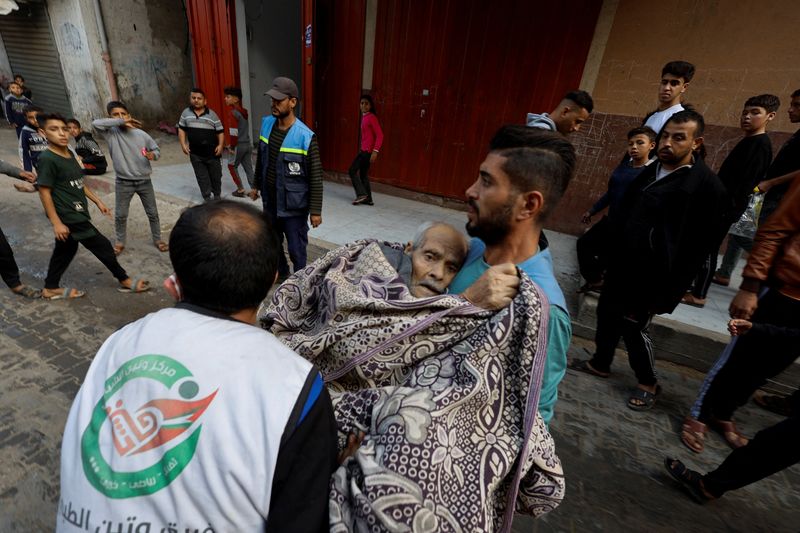 &copy; Reuters. رجل فلسطيني يحمل مسنا بالقرب من موقع ضربات إسرائيلية على منازل بعد انتهاء الهدنة المؤقتة بين حركة حماس وإسرائيل في خان يونس بجنوب قطاع غزة ي