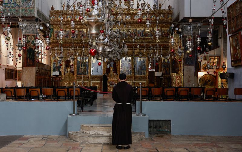 &copy; Reuters. A monk stands inside the Church of the Nativity on the day of the launch of the beginning of the Christmas season, as the conflict between Israel and Palestinian Islamist group Hamas continues, in Bethlehem in the Israeli-occupied West Bank December 2, 20