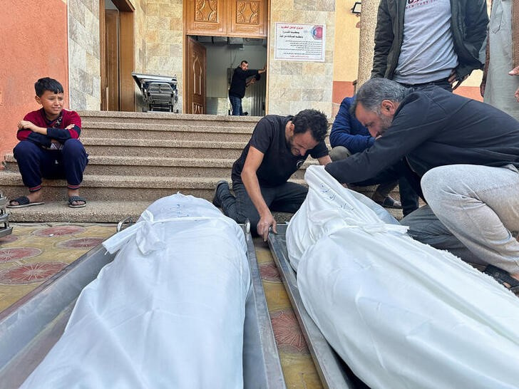 &copy; Reuters. Varias personas se lamentan junto a varios cadáveres de palestinos muertos por los ataques israelíes, en el hospital Nasser de Jan Yunis, en el sur de la Franja de Gaza. 2 diciembre 2023. REUTERS/Fadi Shana