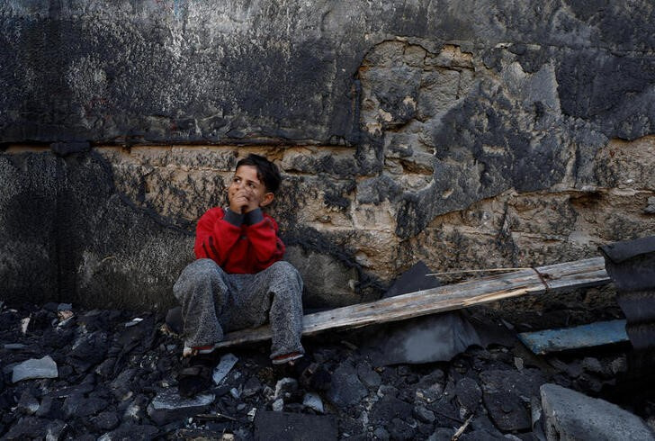 &copy; Reuters. Imagen de archivo de un niño palestino sentado junto a unos escombros en Jan Yunis, en el sur de la Franja de Gaza. 1 diciembre 2023. REUTERS/Mohammed Salem