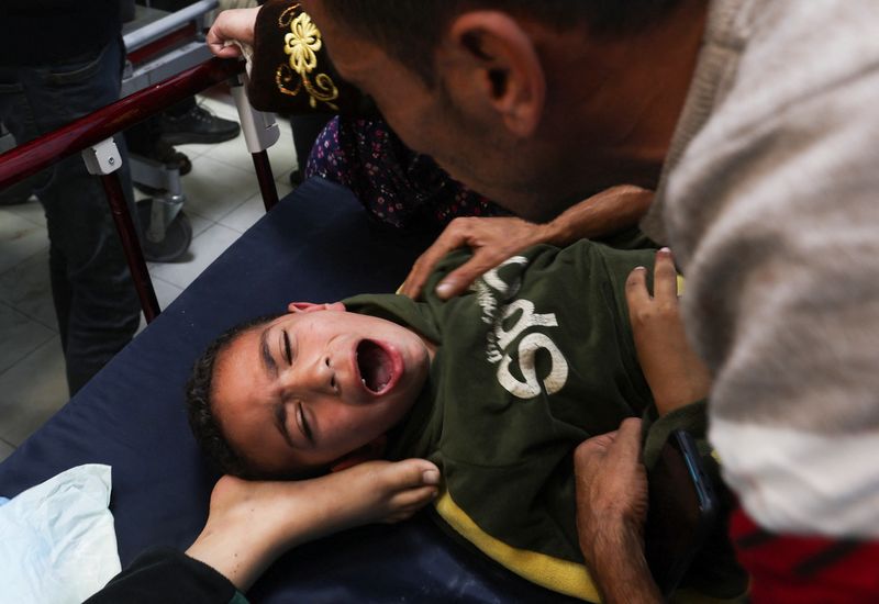 © Reuters. A Palestinian boy is assisted following an Israeli strike, amid the ongoing conflict between Israel and the Palestinian Islamist group Hamas, at Nasser hospital in Khan Younis in the southern Gaza Strip, December 3, 2023. REUTERS/Ibraheem Abu Mustafa