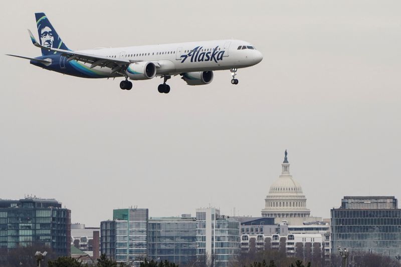 &copy; Reuters. 米アラスカ航空は、ハワイアン航空を純債務９億ドル込みの１９億ドルで買収することで合意した。両社が３日発表した。写真は２０２２年１月、米バージニア州アーリントンの空港に着陸