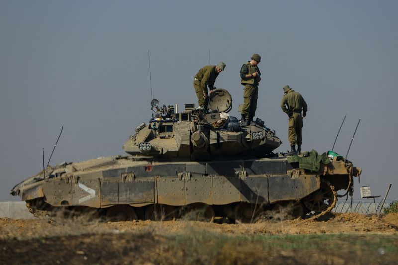 &copy; Reuters. Israeli soldiers work on a tank near the border with Gaza, amid the ongoing conflict between Israel and the Palestinian Islamist group Hamas, as seen from southern Israel, December 3, 2023. Picture taken through a window. REUTERS/Alexander Ermochenko