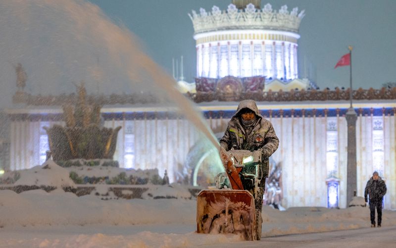 &copy; Reuters. عامل ينظف الثلج في معرض إنجازات الاقتصاد الوطني خلال تساقط الثلوج بكثافة علي موسكو يوم الأحد. تصوير : ماكسيم شيمتوف - رويترز.