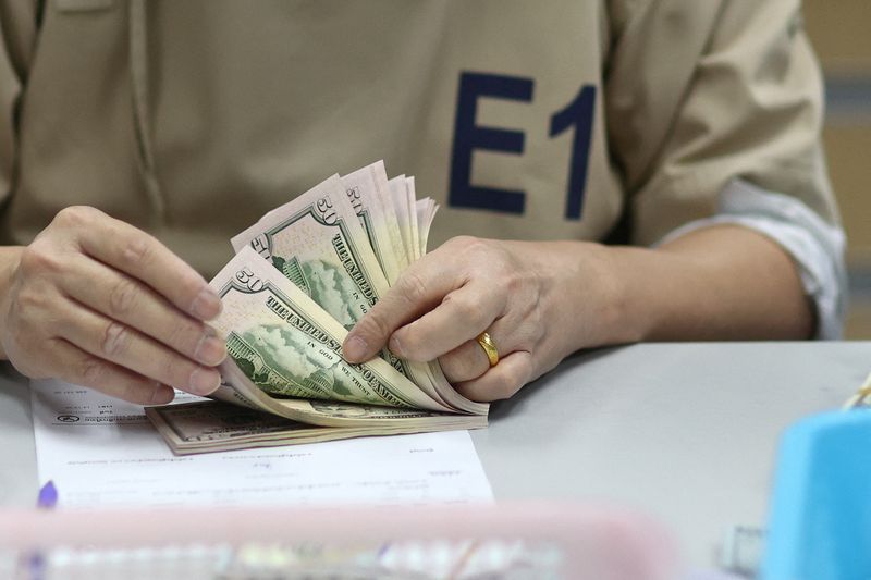 &copy; Reuters. موظف ببنك يعد أوراقا مالية من الدولار الأمريكي في بنك ببانكوك يوم 23 يناير كانون الأول 2023. تصوير: أتيت بيراونجميتا - رويترز.