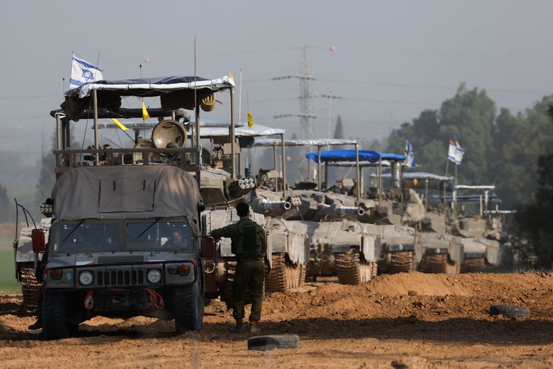 &copy; Reuters. Un soldado israelí junto a un vehículo militar y un convoy de tanques cerca de la frontera de Israel con Gaza, en medio del actual conflicto entre Israel y el grupo islamista palestino Hamás, en Israel. 4 de diciembre de 2023. REUTERS/Amir Cohen
