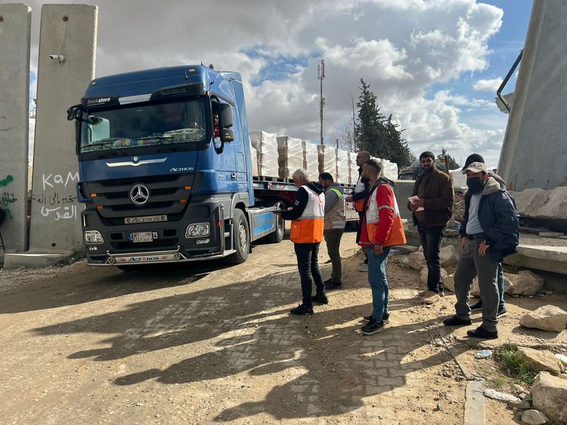 &copy; Reuters. فريق من الهلال الأحمر الفلسطيني يستقبلون شاحنة تحمل مساعدات إنسانية عند معبر رفح الحدودي بين مصر وقطاع غزة يوم السبت. صورة لرويترز من الهلا