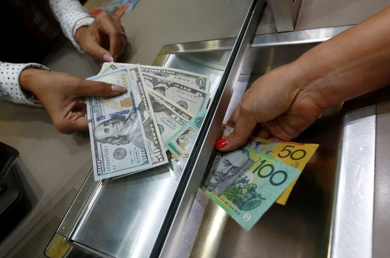© Reuters. FILE PHOTO: Australian dollar and U.S. dollar denominations are shown in a photo illustration at a currency exchange in Sydney, Australia, June 7, 2016. REUTERS/Jason Reed/File Photo