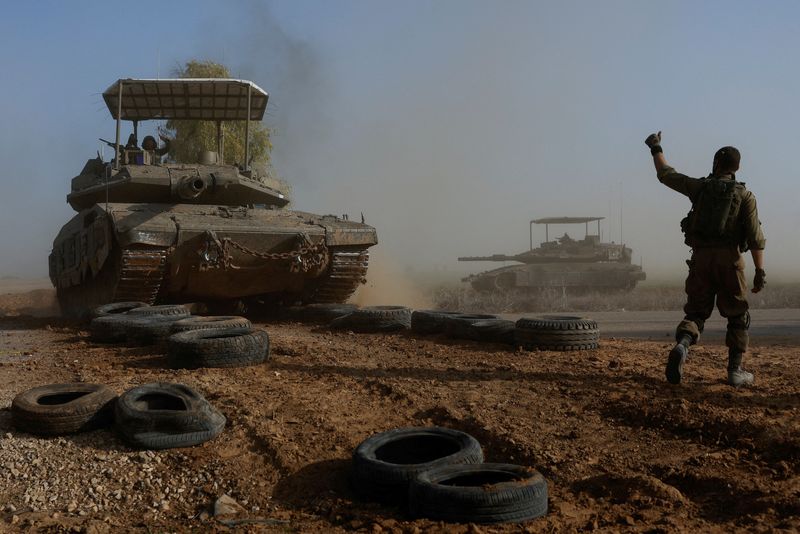 &copy; Reuters. Un soldado israelí gesticula hacia un miembro de la cuadrilla de un tanque mientras cruza una carretera, como parte del convoy, en medio del conflicto en curso entre Israel y el grupo islamista palestino Hamás, cerca de la frontera de Israel con el sur 