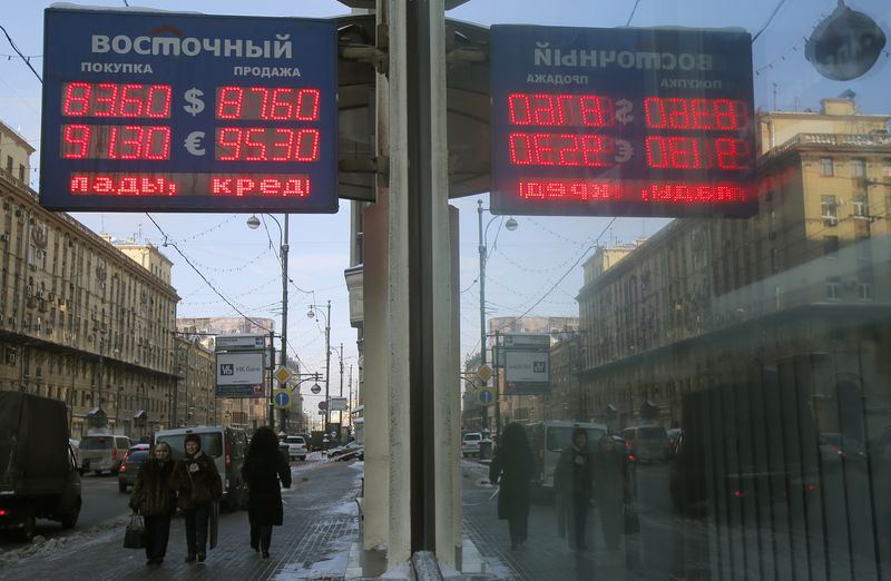 &copy; Reuters. FILE PHOTO: People walk near a board showing currency exchange rates of the U.S. dollar and euro against the rouble in Moscow, Russia, January 21, 2016. REUTERS/Maxim Shemetov/File Photo