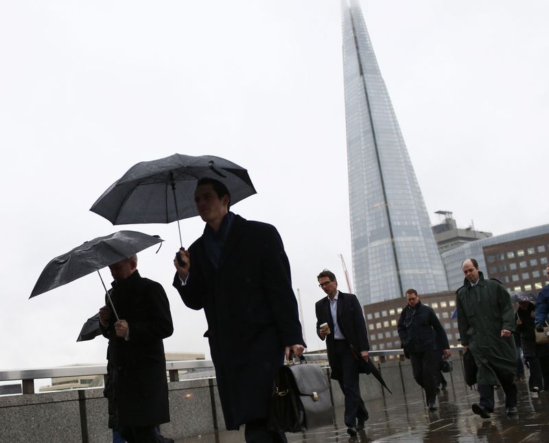 &copy; Reuters. Des employés s'abritant de la pluie à Londres. /Photo d'archives/REUTERS/Eddie Keogh