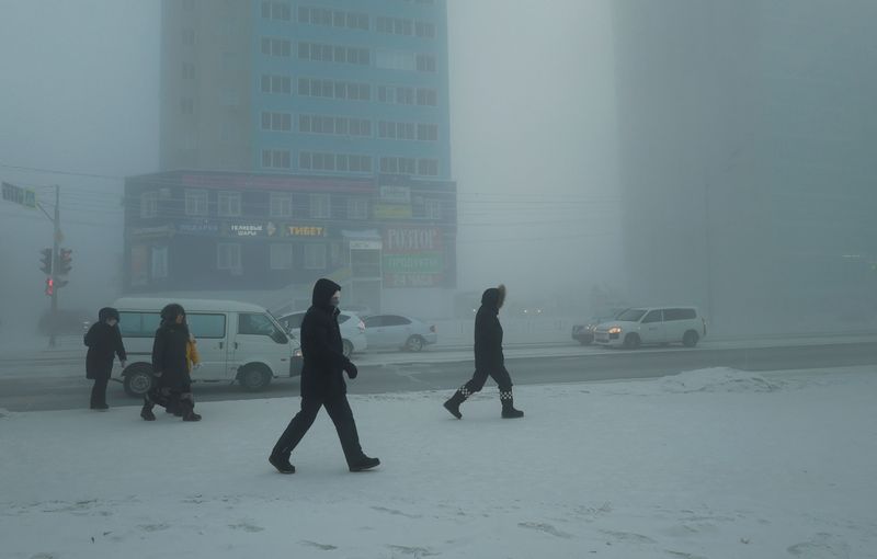 &copy; Reuters. مشاة يسيرون في أحد الشوارع في يوم بارد في مدينة ياكوتسك بروسيا يوم الثلاثاء. تصوير: رومان كوتوكوف-رويترز.