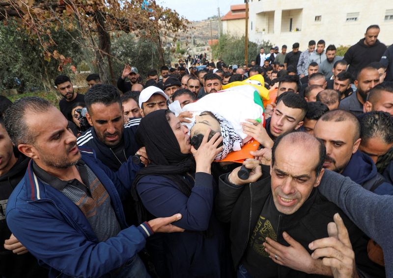 &copy; Reuters. Varias decenas de personas llevando el cuerpo de un palestino muerto durante unos enfrentamientos, durante su funeral cerca de Hebrón, en Cisjordaniam, territorio ocupado por Israel. 5 de diciembre de 2023. REUTERS/Yosri Aljamal