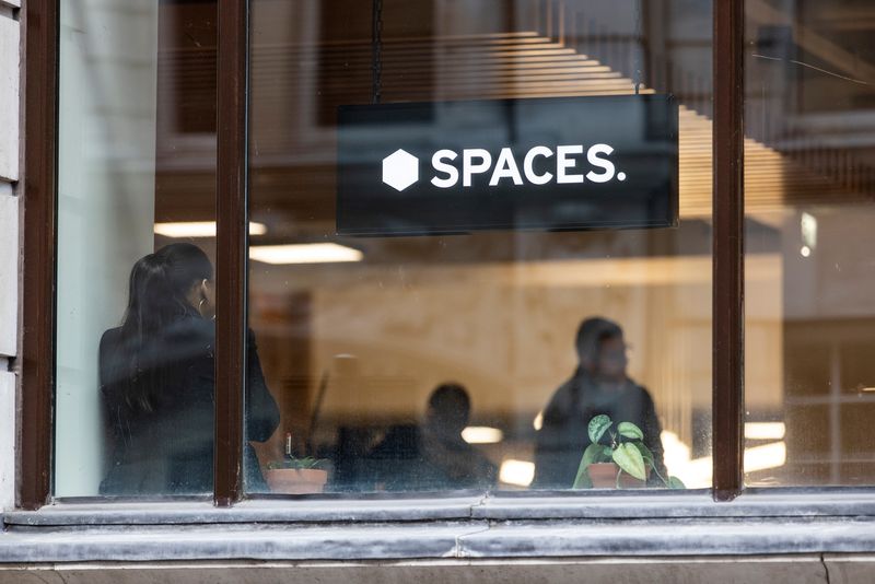 &copy; Reuters. FILE PHOTO: A person stands close to a window inside a Spaces office workspace, an IWG brand, in London, Britain, December 1, 2021. Picture taken December 1, 2021.   REUTERS/May James/File Photo
