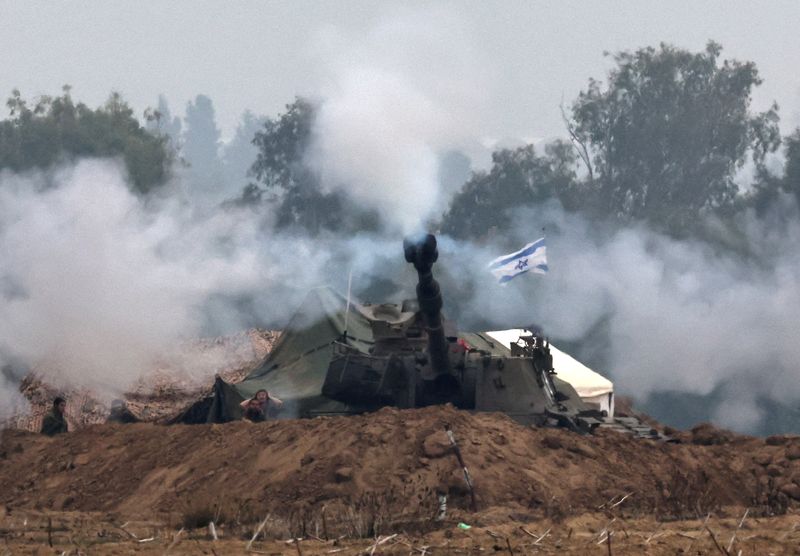 © Reuters. وحدة مدرعة إسرائيلية تعمل عند الحدود مع غزة كما شوهدت من جنوب إسرائيل يوم الثلاثاء. تصوير: أتيت بيراونجميتا - رويترز.